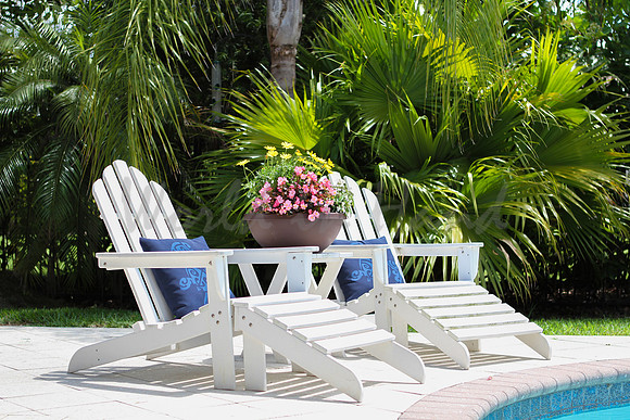 poolside lounge chairs in tropical seting