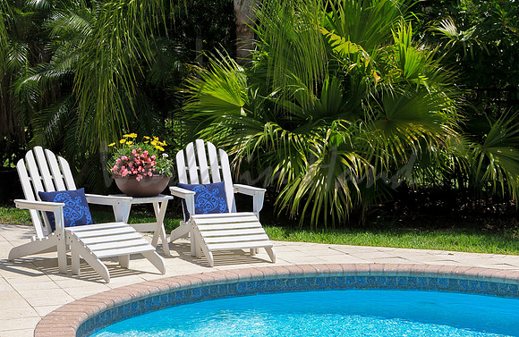 poolside lounge chairs in tropical seting